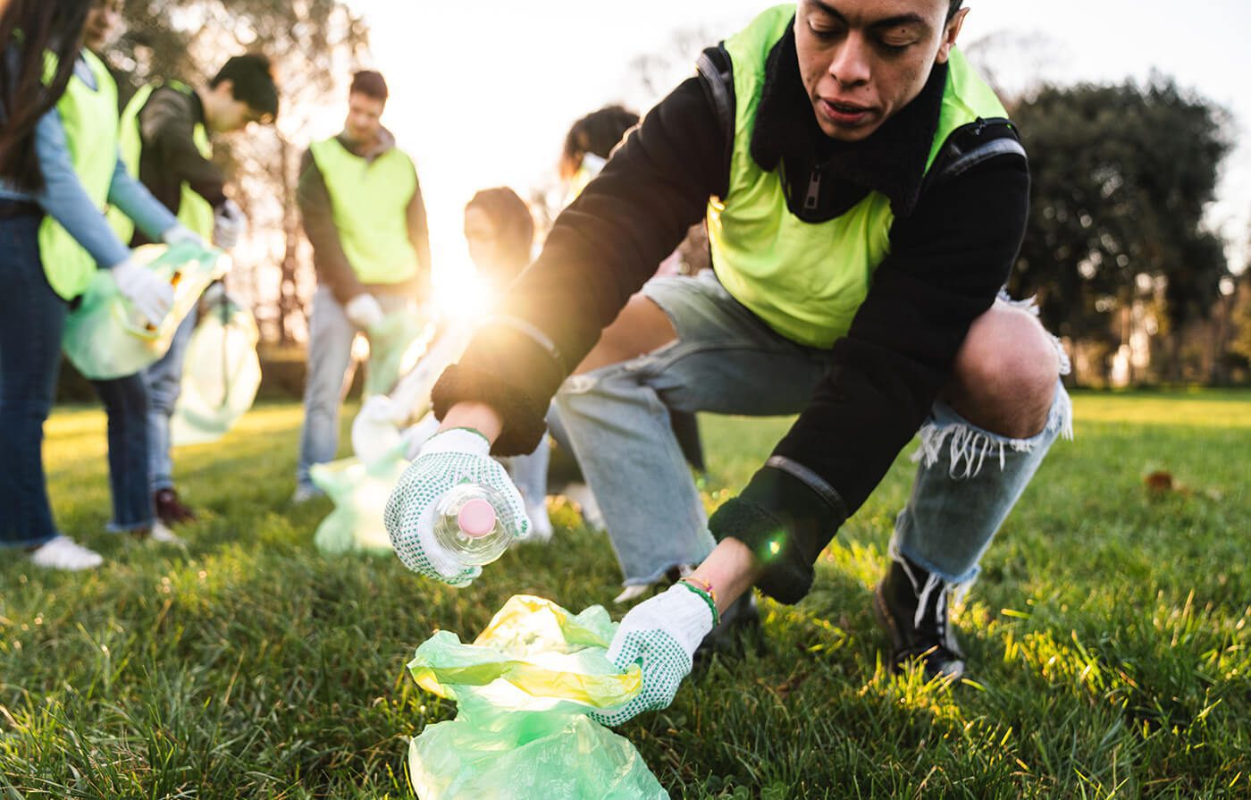 Man in the park collecting plastic waste, highlighting the urgent need to end plastic waste