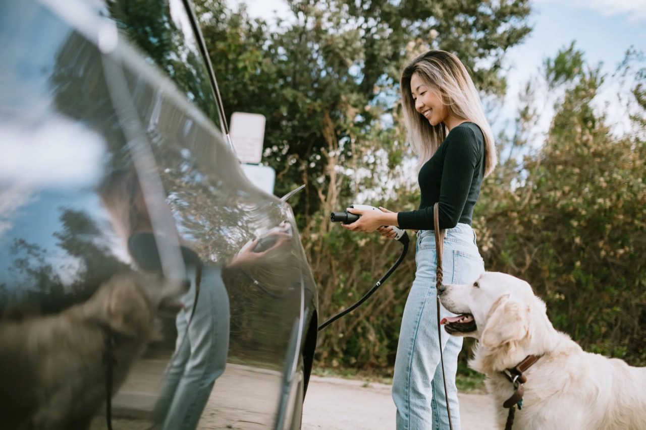 Electric vehicle being connected to a public charging station on the side of a road