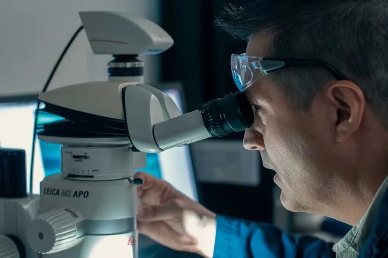 Dell looks through a scientific instrument