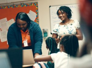 renisha speaks in front of a group of children