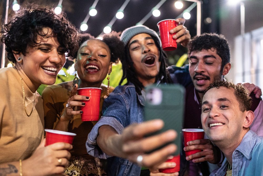Friends at party holding red plastic cups.