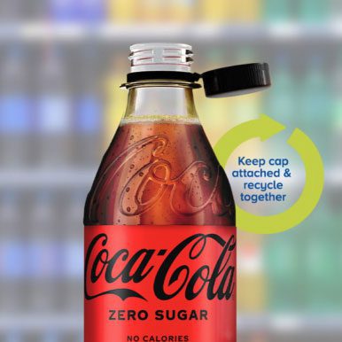 Clear plastic soda bottle with a tethered cap strap attached to its neck