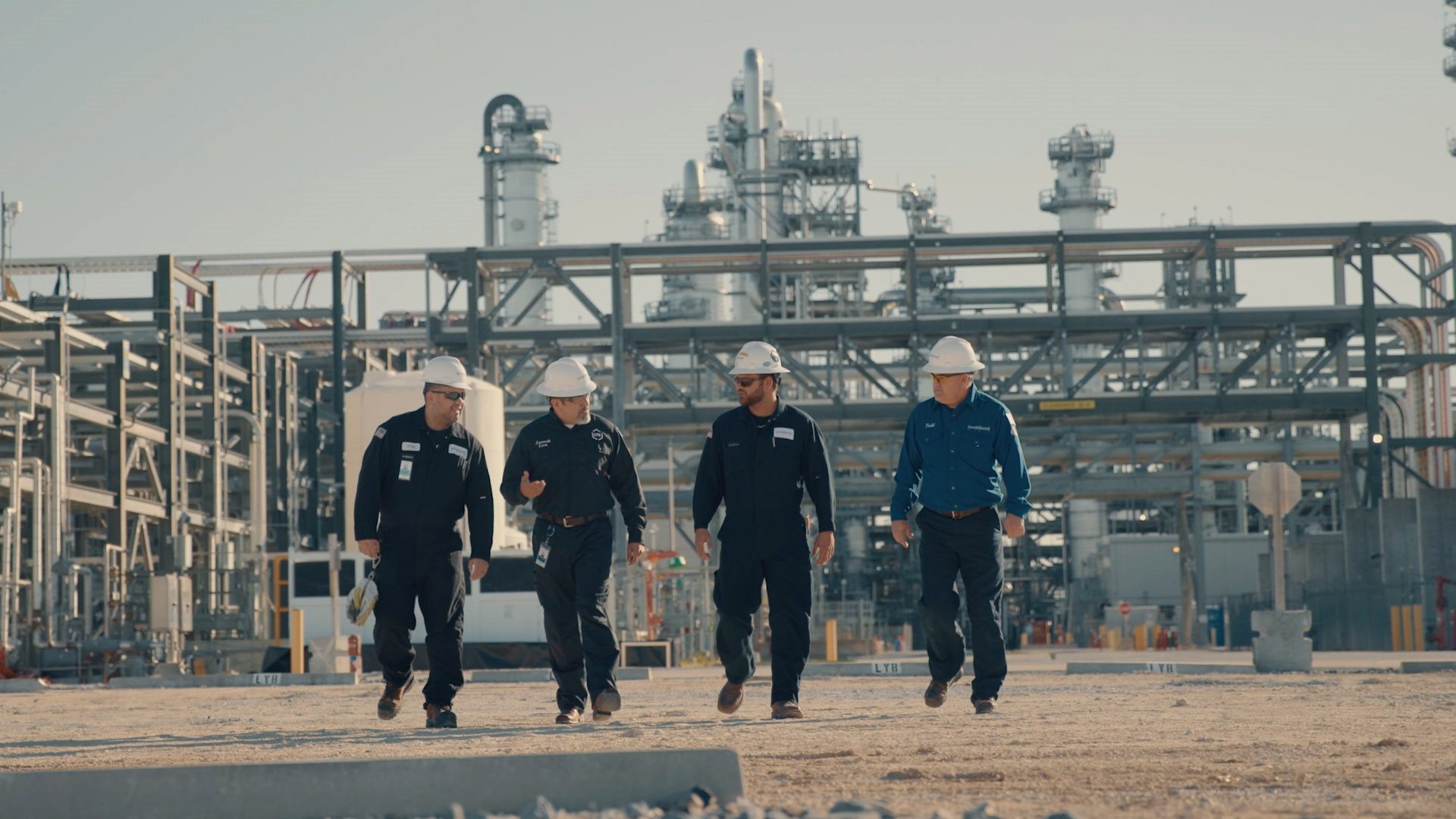 Workers walking in a line outside a manufacturing facility