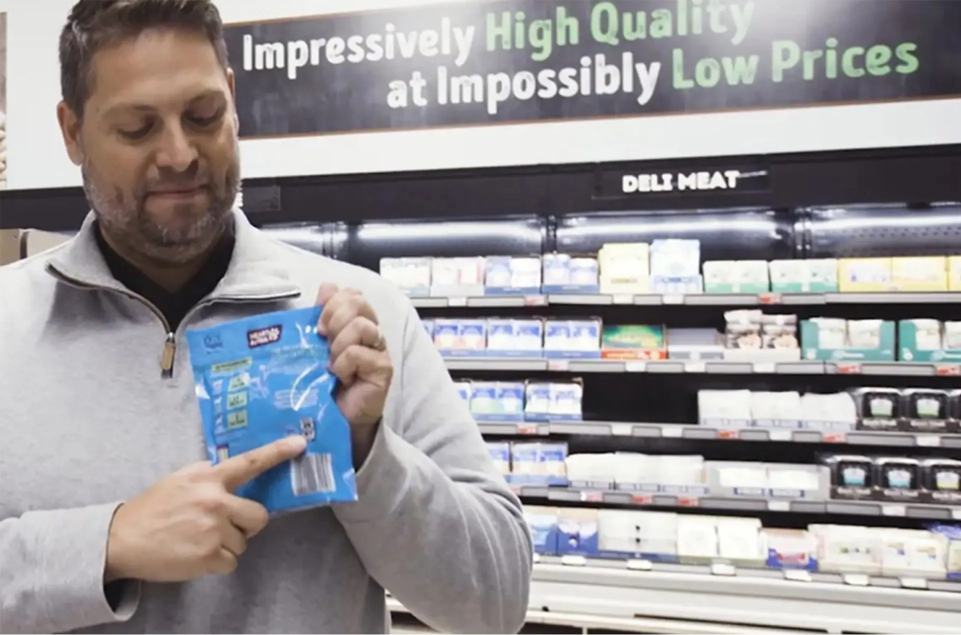 A man pointing to a recycling icon on a plastic package.