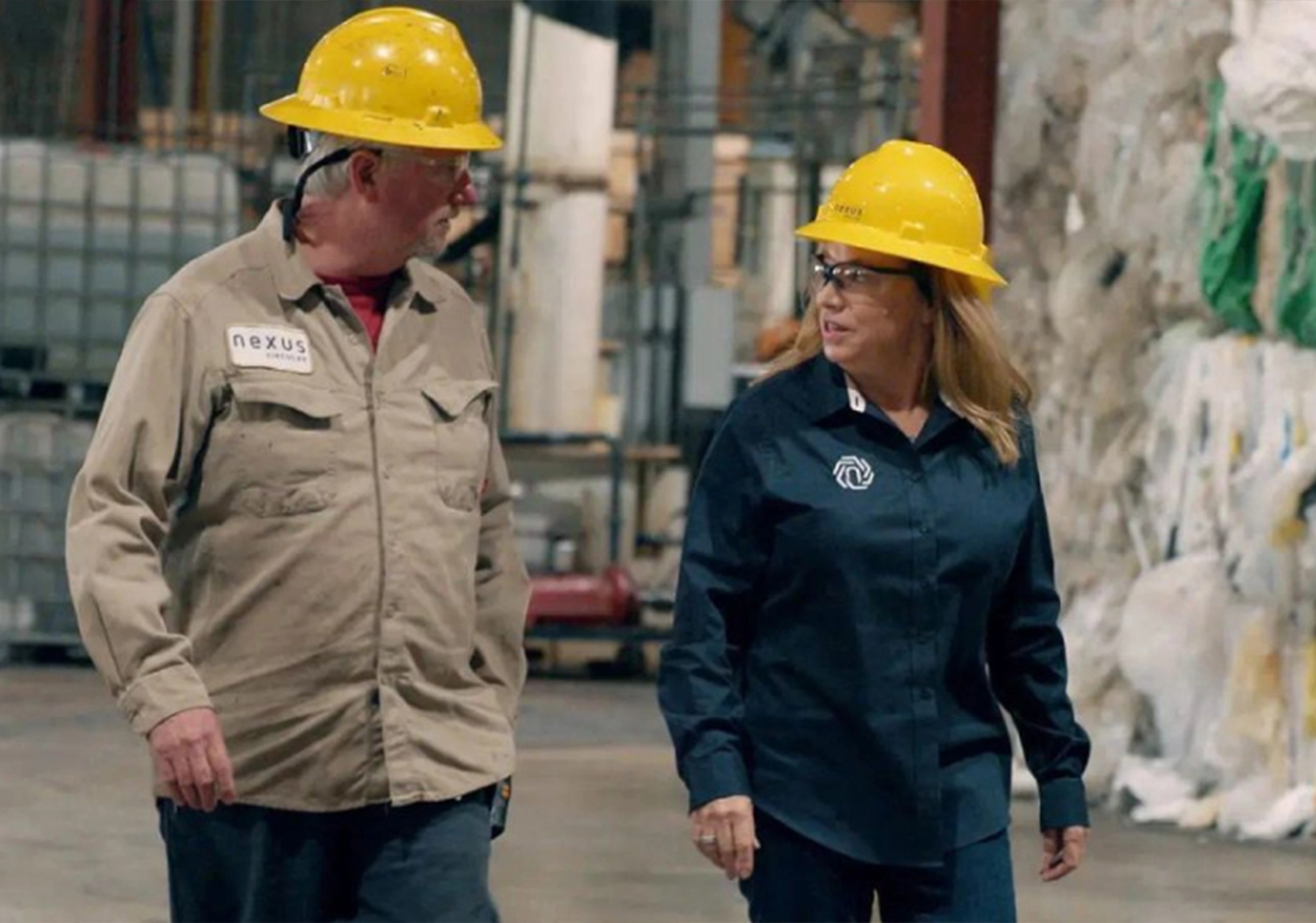 Workers discussing sustainable plastic solutions on a factory floor