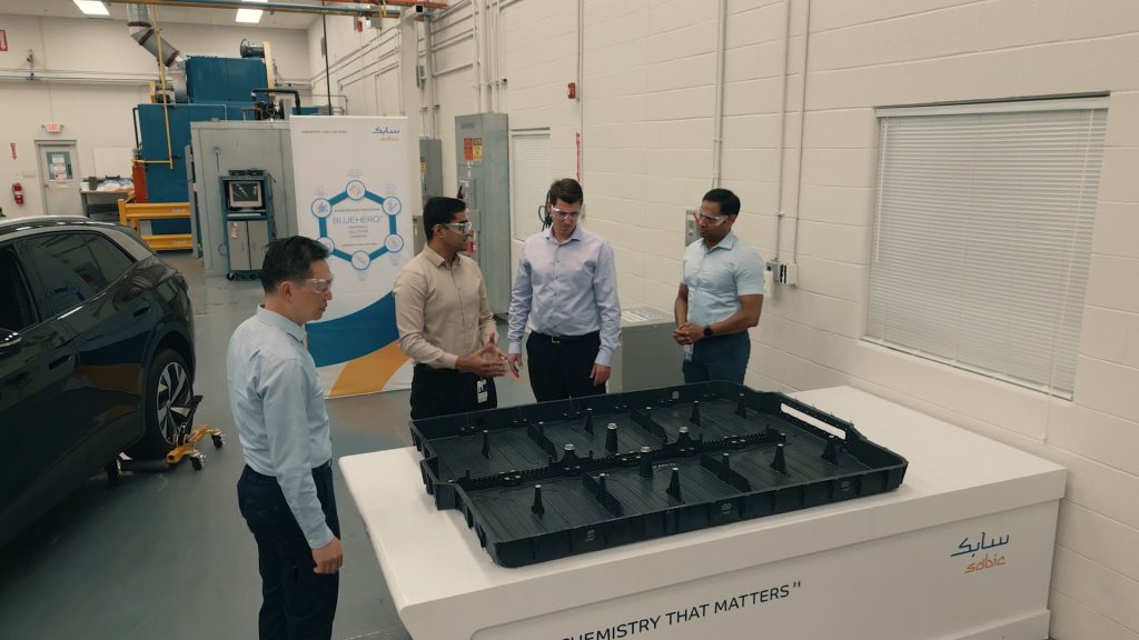 Dinesh and coworkers chat around a piece of plastic. 