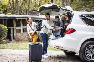 A family loading suitcases into a car.