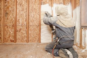 A worker spraying foam insulation.