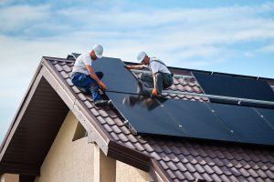 Workers installing solar panels on the roof of a building.