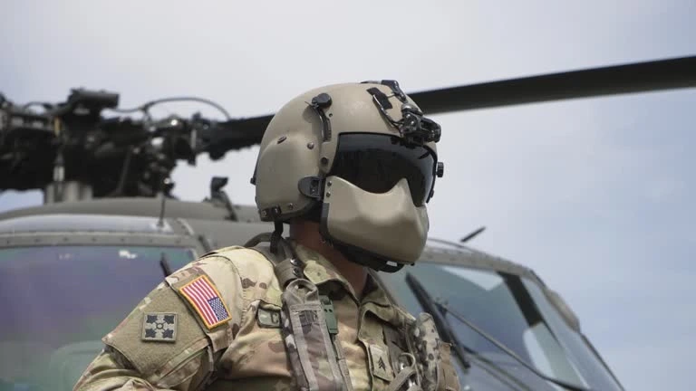 Military soldier in front of landed helicopter on battle field