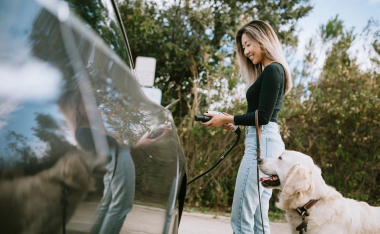 Electric vehicle being connected to a public charging station on the side of a road