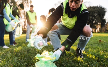Man in the park collecting plastic waste, highlighting the urgent need to end plastic waste
