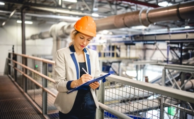 A woman in factory taking notes