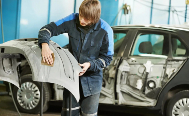 Someone in an auto shop cleaning parts of an automobile